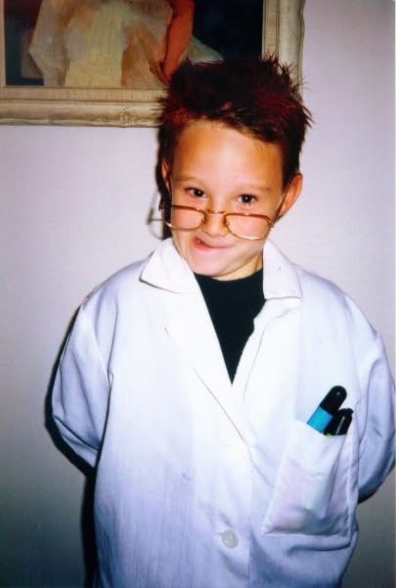 Taylor Bullock as a child dressed in a white coat with test tubes